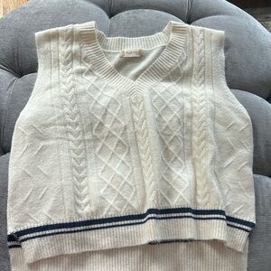 Sleeveless sweater with Blue stripe - color is an off white or light cream.
